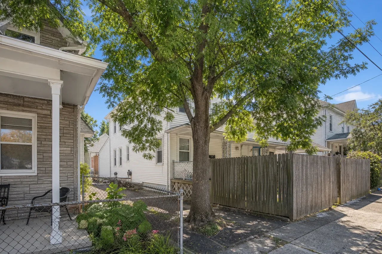 Compact borough lot with mature trees near sidewalks and homes